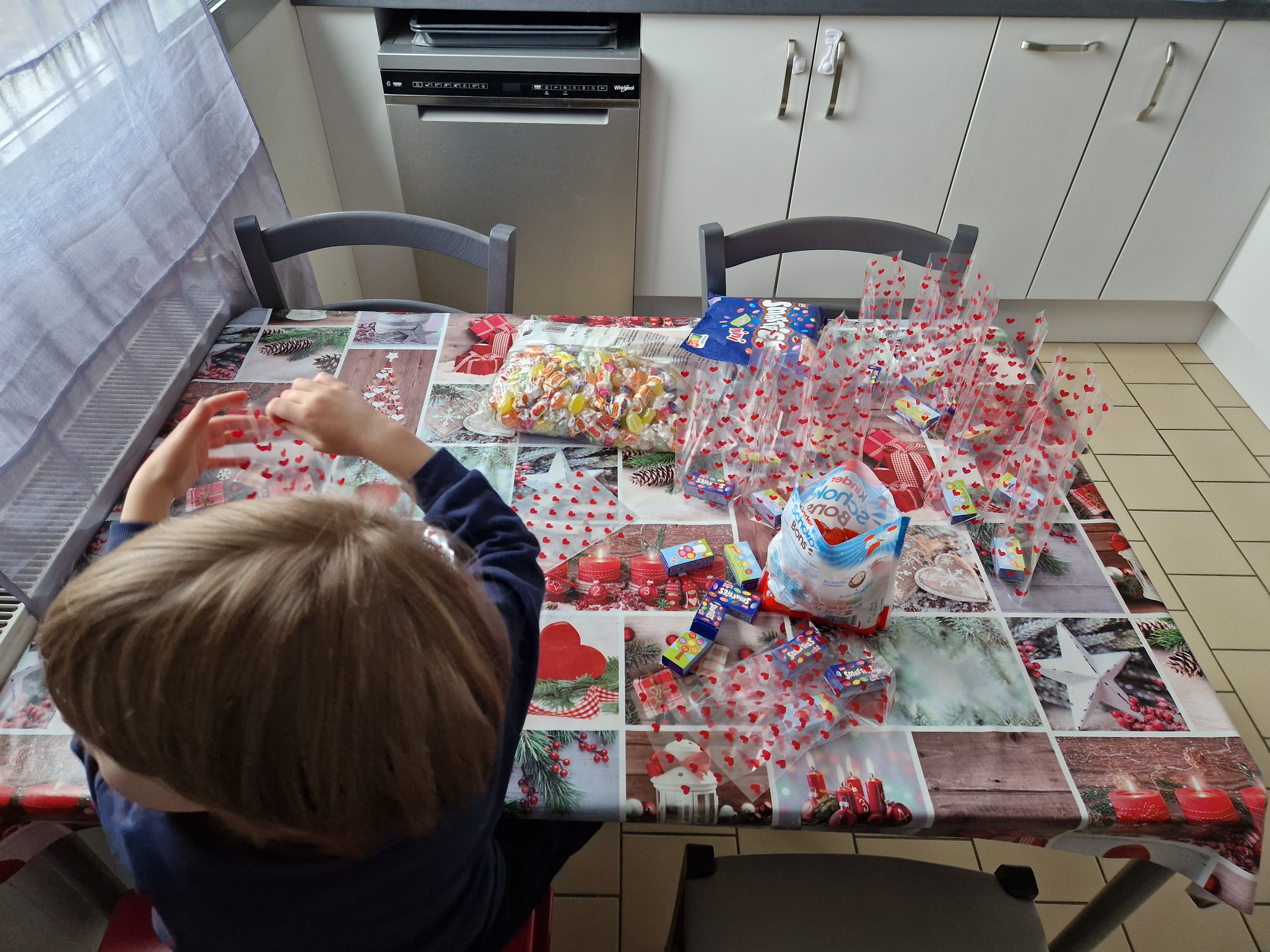 Enfant qui remplit les sachets de bonbons pour l'école, vu de dos
