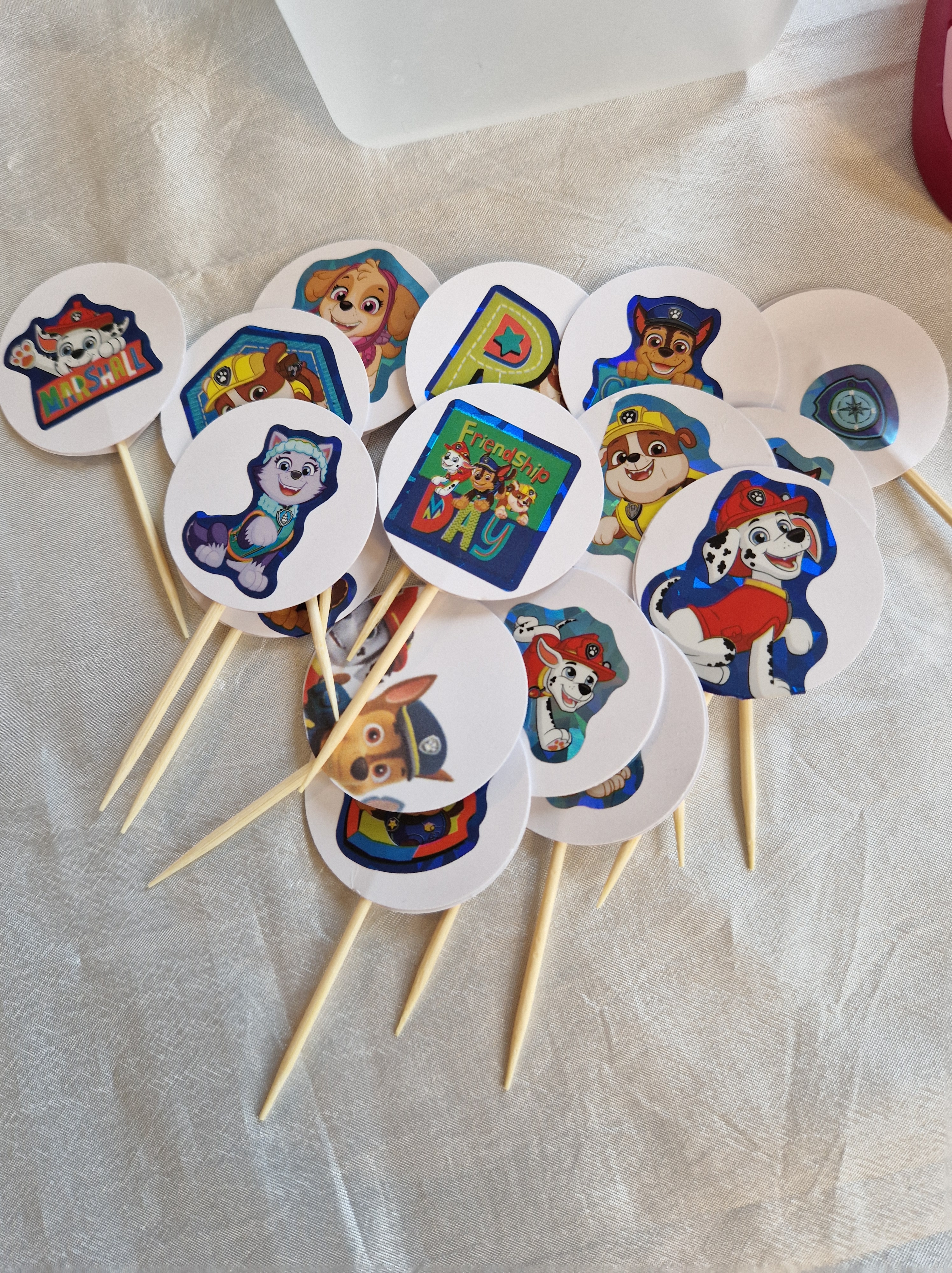 Piques à muffins terminés, avec les personnages de la Pat'Patrouille collés sur des ronds de papier