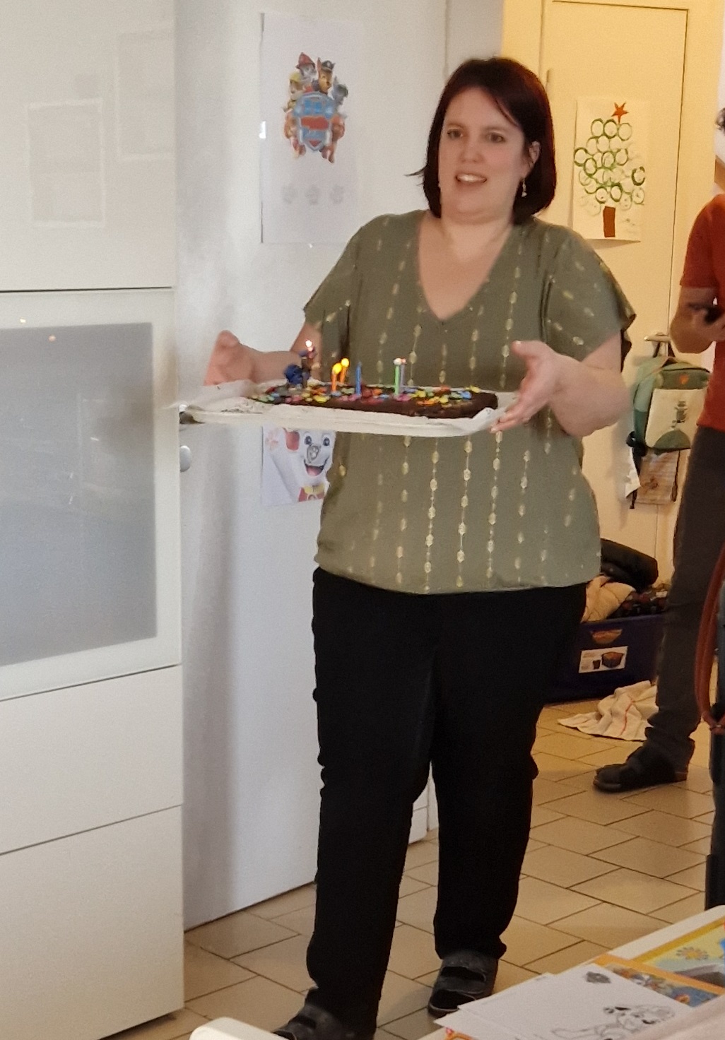 Laura apporte le gâteau d'anniversaire avec les bougies allumées
