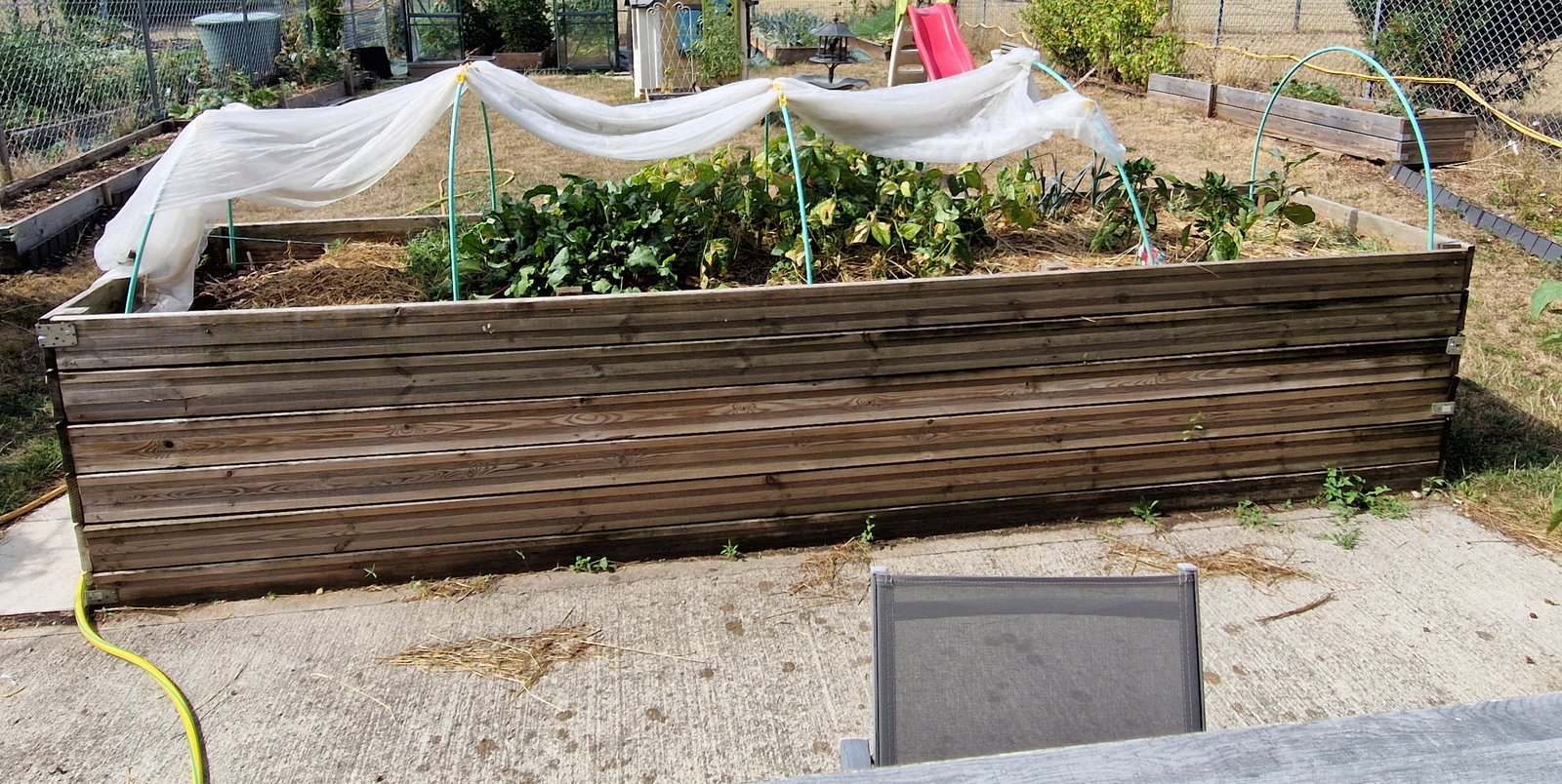 Grand bac potager surélevé en lames de terrasse, en bon état