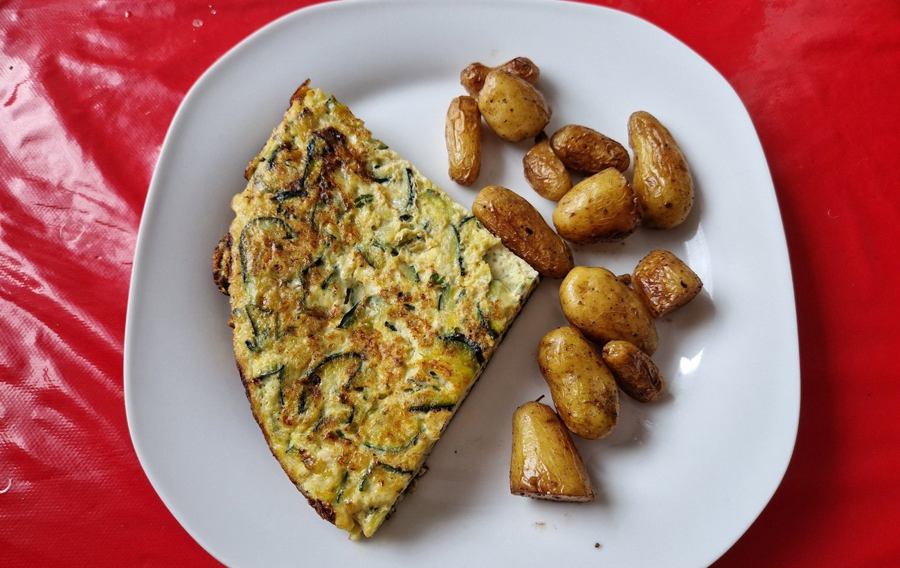 Part de frittata de courgettes servie avec des pommes de terre